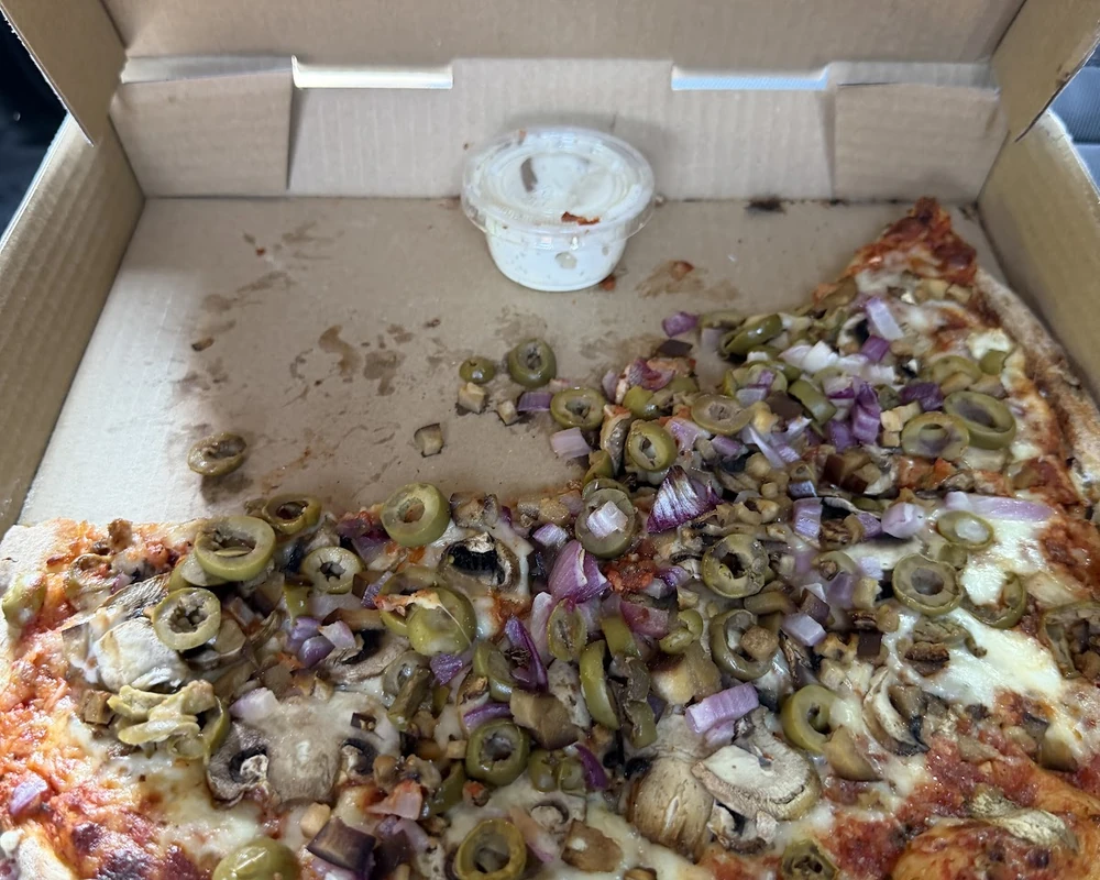 Pizza slice with garlic dipping sauce at Ancaster Pizza